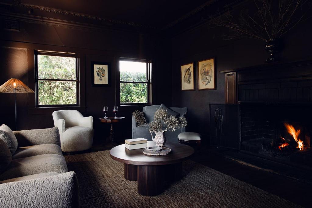 a living room with a couch and a fire place at Links House in Bowral