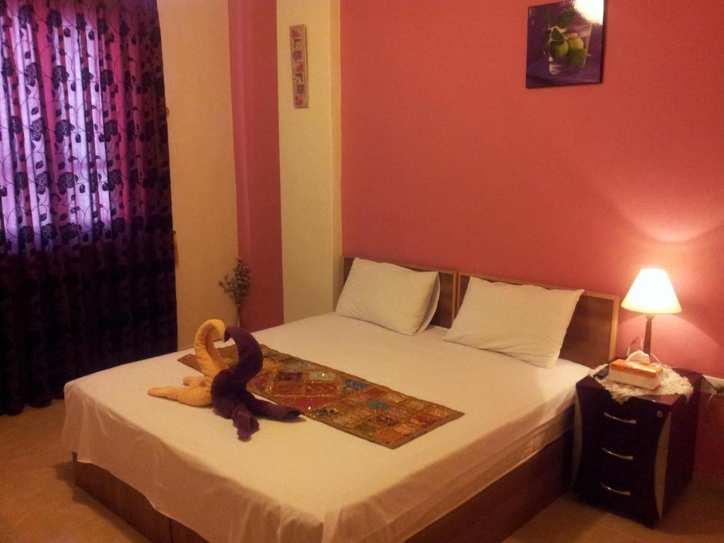 um quarto com uma cama com um bicho de peluche em Jordan River Hotel em Amã