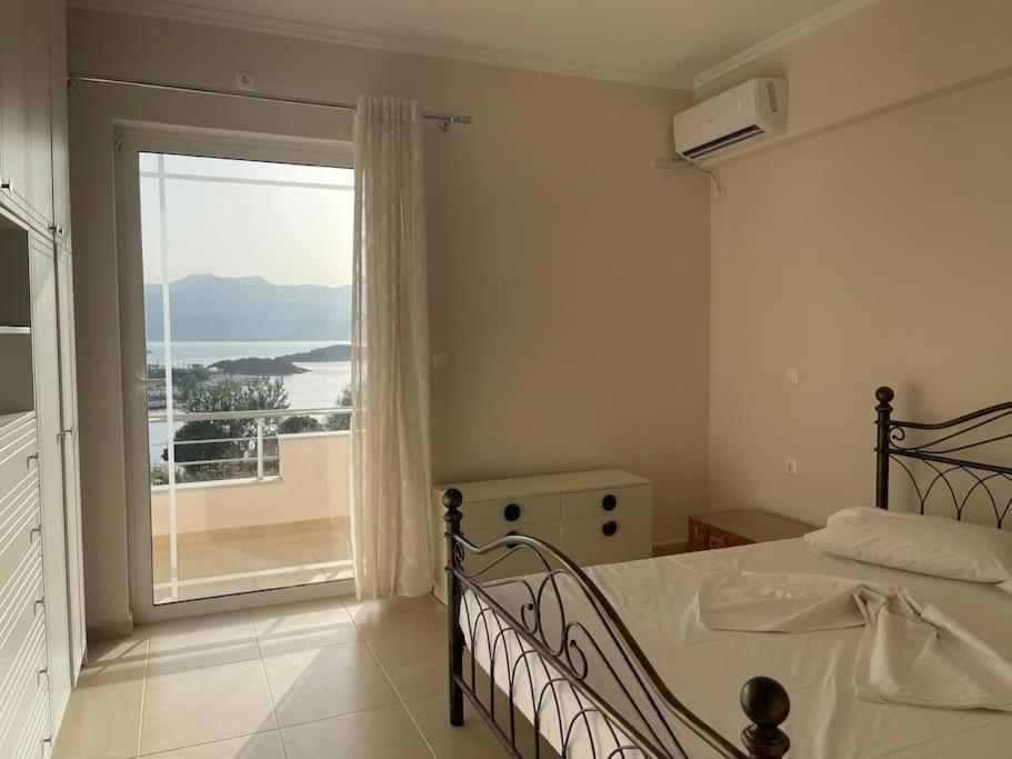 Un dormitorio con una cama y una ventana grande. en Vila Athina, en Ksamil