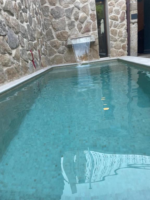 una piscina de agua azul claro en LA CASONA DE BAUTISTA 4 estrellas con piscina montanchez CACERES en Montánchez