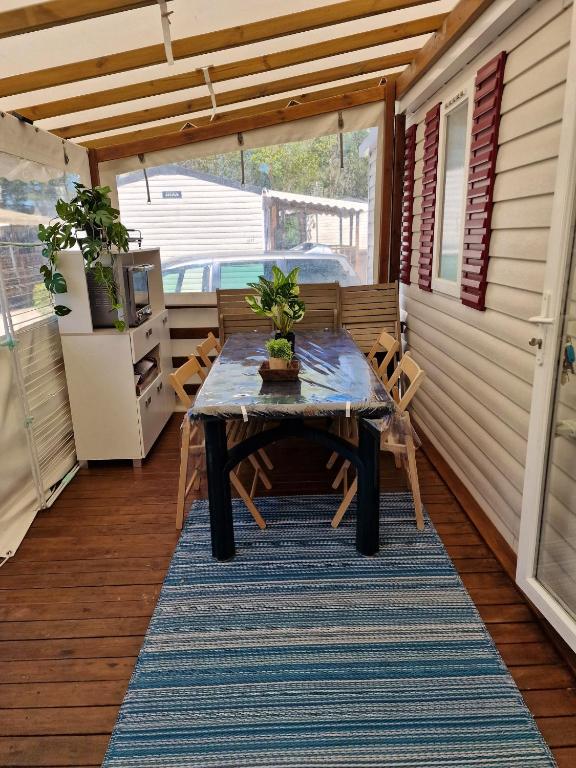 a table on the back porch of a tiny house at Bungalow de 3 chambres avec piscine partagee et terrasse a Vias a 1 km de la plage in Vias