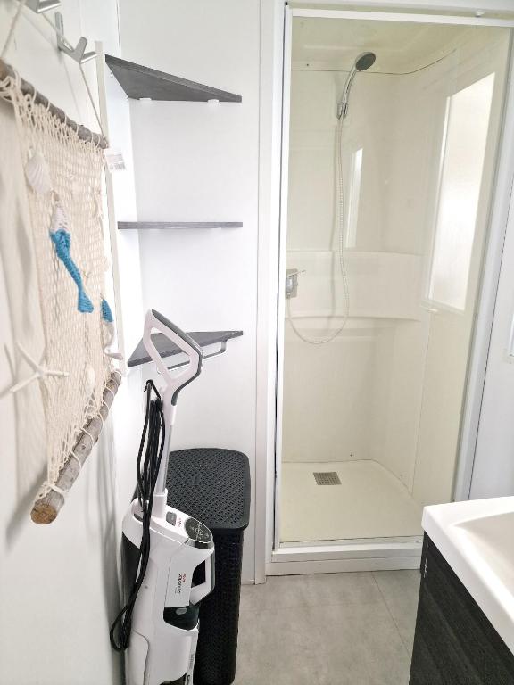 a white kitchen with a shower and a hair dryer at Bungalow de 3 chambres avec piscine partagee et terrasse a Vias a 1 km de la plage in Vias