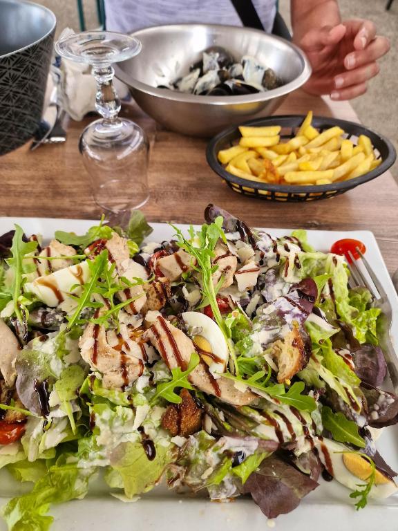 a plate of food with a salad and french fries at Bungalow de 3 chambres avec piscine partagee et terrasse a Vias a 1 km de la plage in Vias