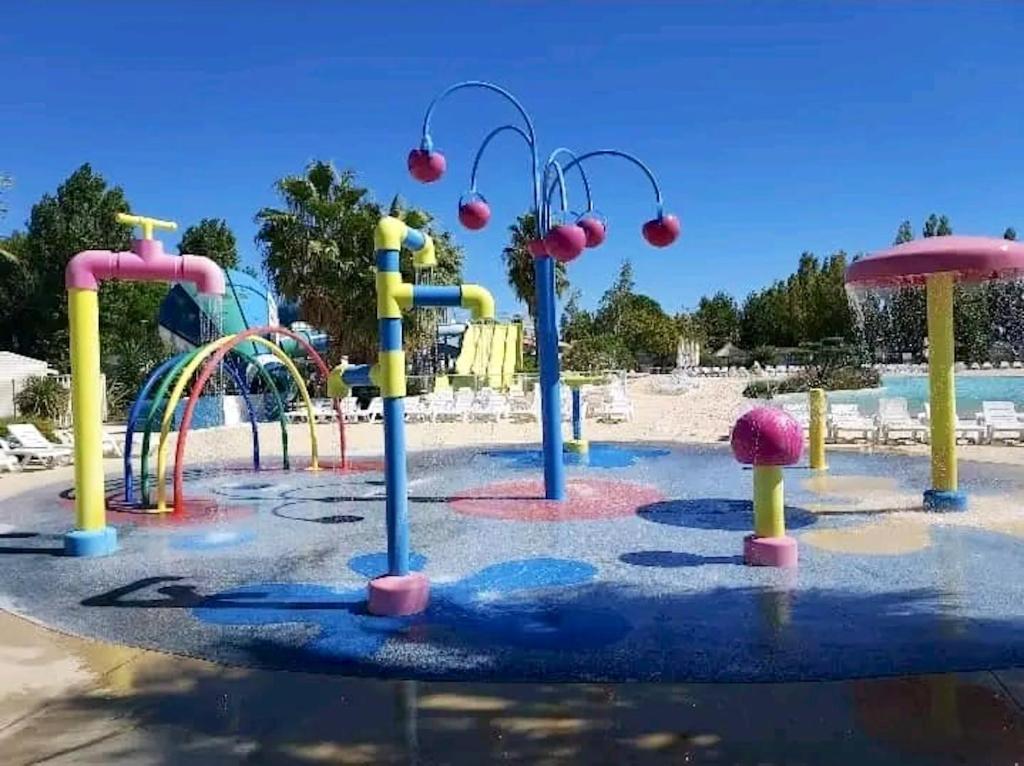 a water park with a colorful water slide at Bungalow de 3 chambres avec piscine partagee et terrasse a Vias a 1 km de la plage in Vias