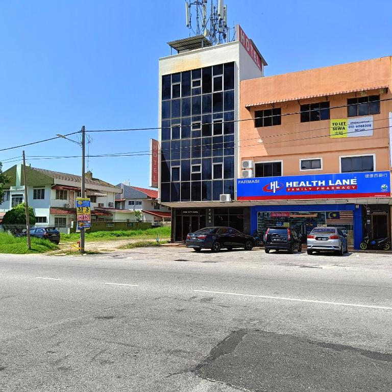 a large building with cars parked in front of it at Park City Motel in Melaka