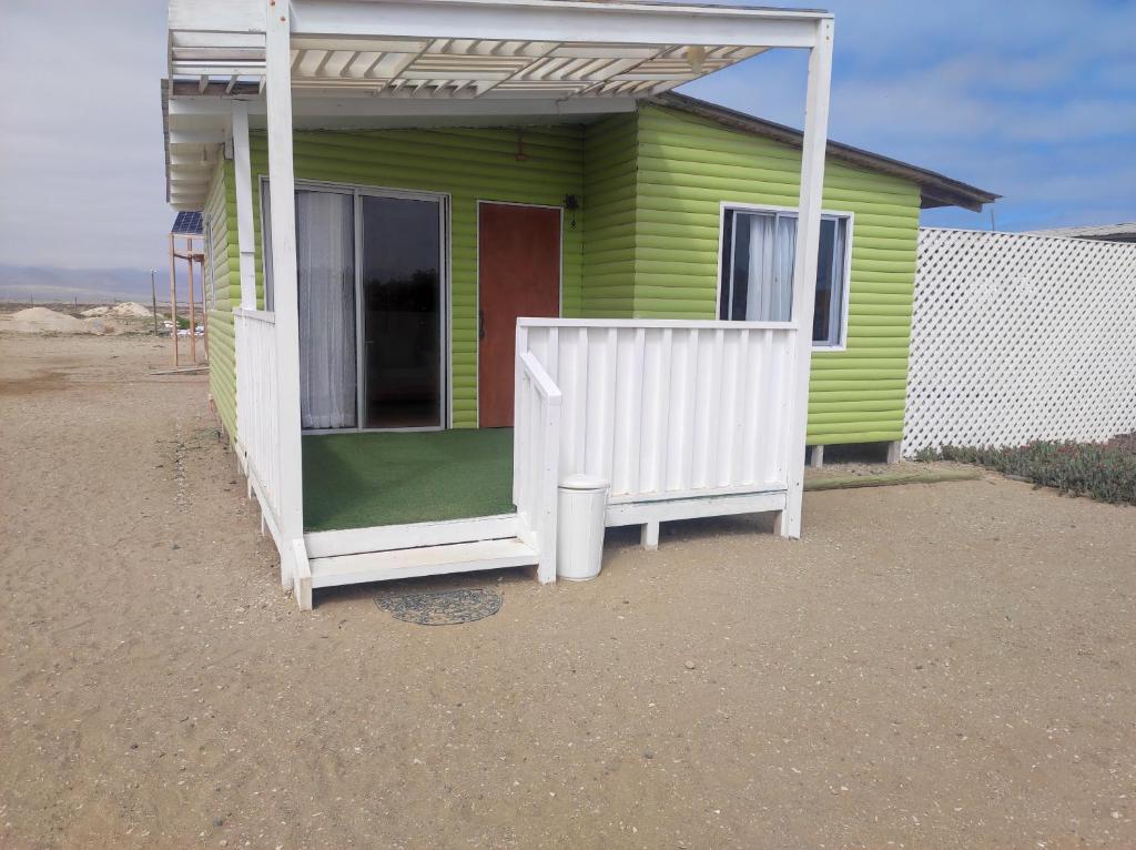 una casa verde y blanca con puerta roja en Cabaña2 Punta de Choros, en Choros