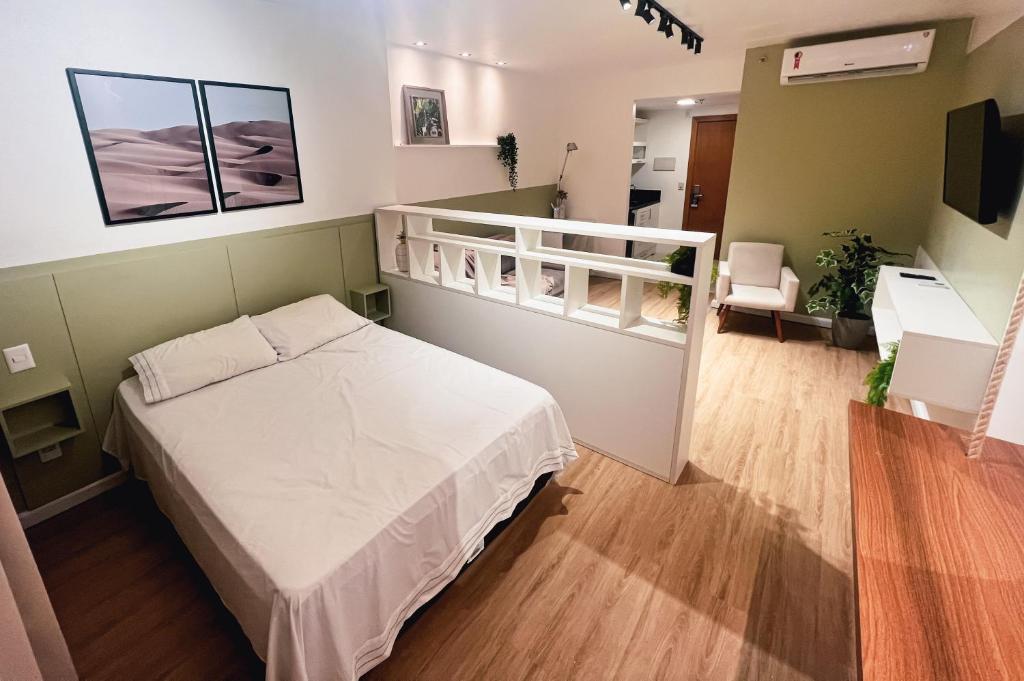 a bedroom with a white bed and a living room at Iguatemi Business & Flat in Salvador