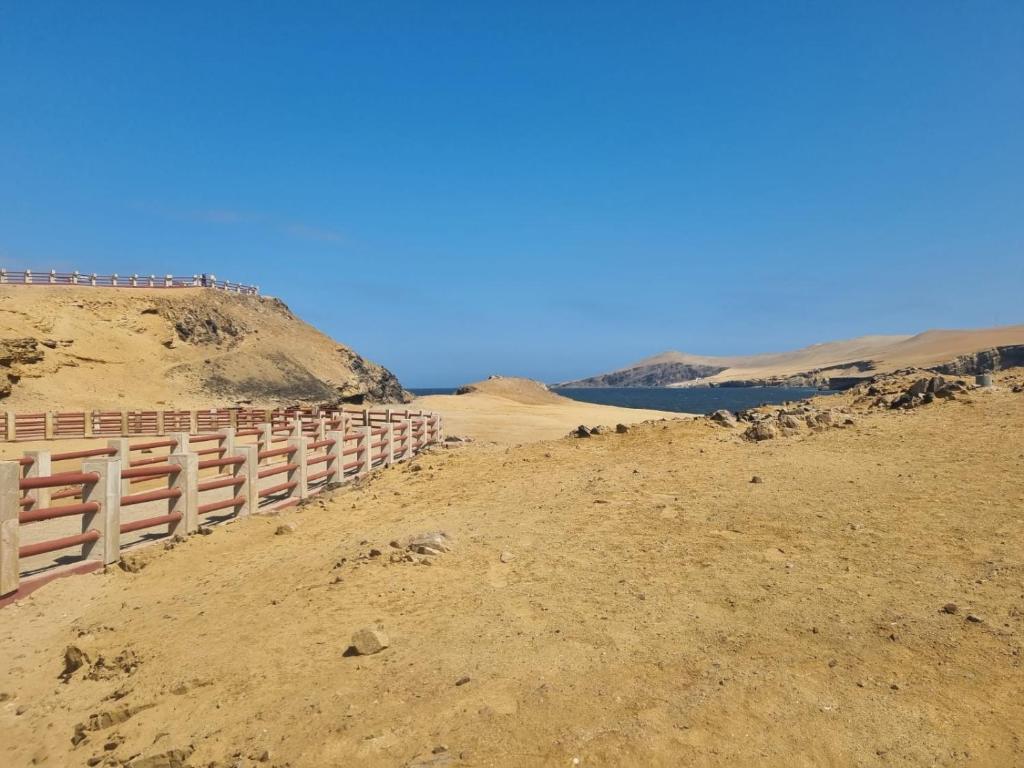 a fence on the side of a hill in the desert at Soinca Backpacker Hospedaje in Paracas