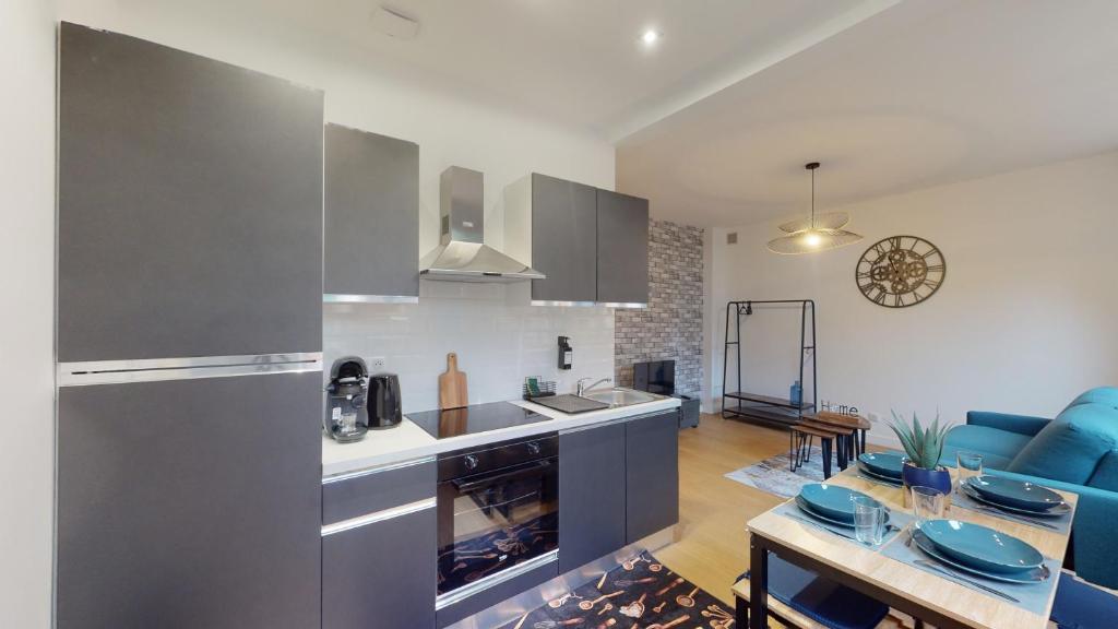 Il comprend une cuisine et un salon avec une table. dans l'établissement A l'abri du tumulte de la ville, à Charleville-Mézières