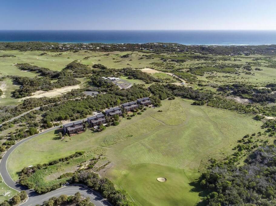 an aerial view of a golf course with the ocean at The Golf House at St Andrews Beach in Fingal