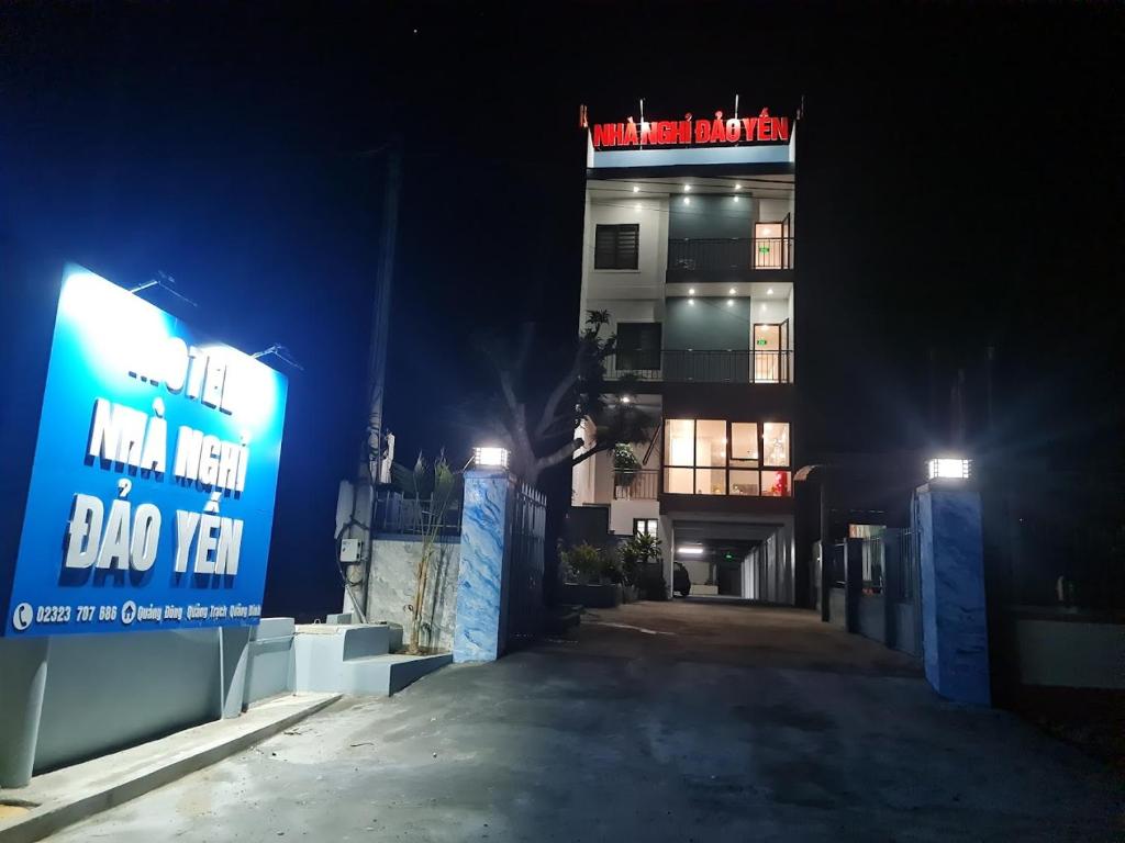 un edificio con un cartel delante de él por la noche en Nhà Nghỉ Đảo Yến 