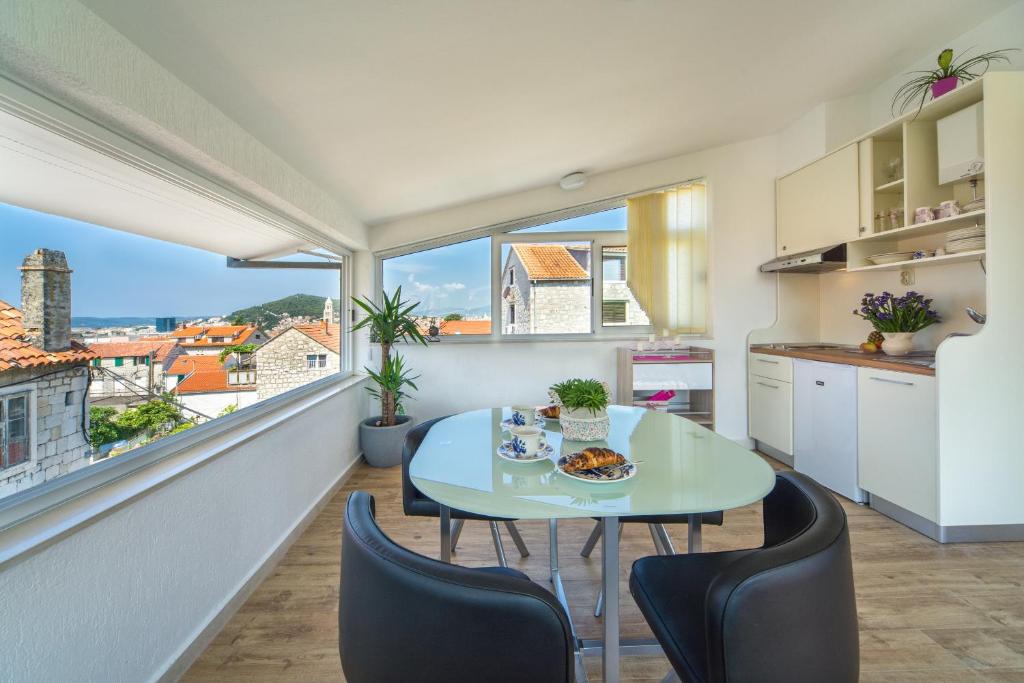 a kitchen with a table and chairs and a large window at Cherry-old town in Split