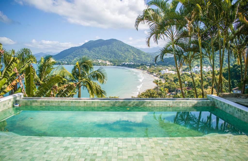 a swimming pool with a view of the beach at Catalina Hotel in Ubatuba