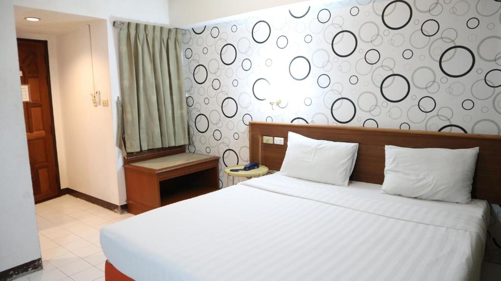 a bedroom with a white bed and a wall with circles at Patong Triple P in Patong Beach