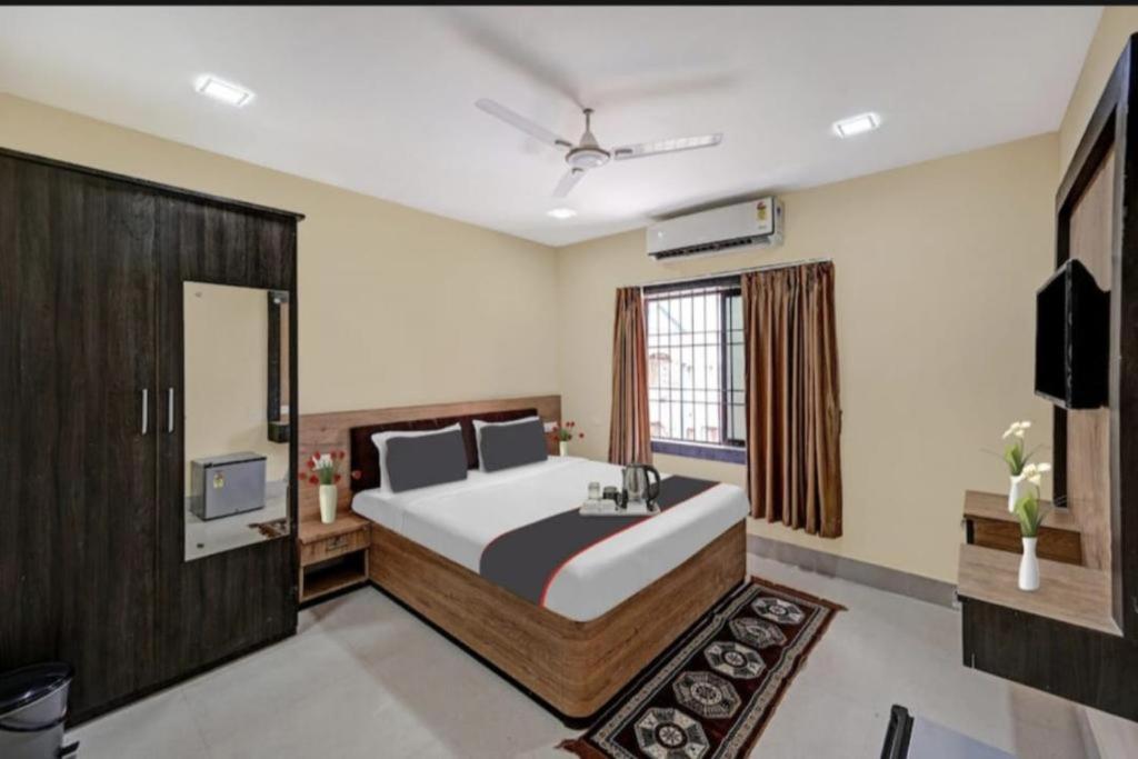 a bedroom with a large bed and a television at Goroomgo Moon Light Guest House Bhubaneswar Near Patia in Bhubaneshwar