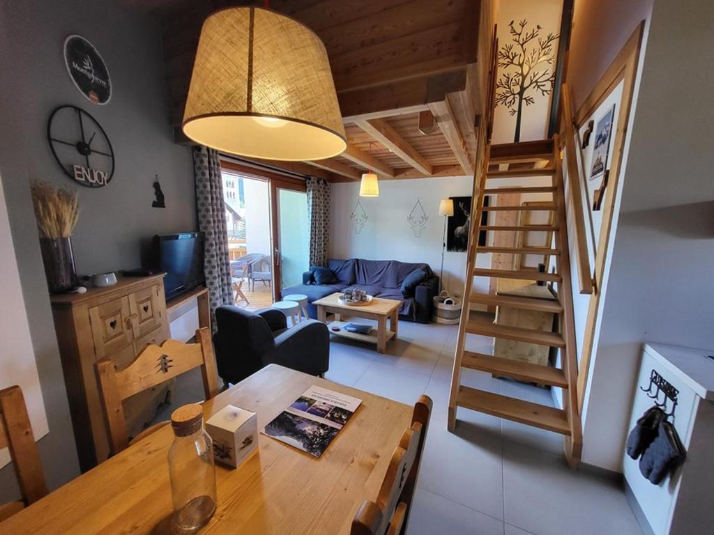 a living room with a dining room table and a staircase at Appartement Montgenèvre, 3 pièces, 4 personnes - FR-1-266-213 in Montgenèvre