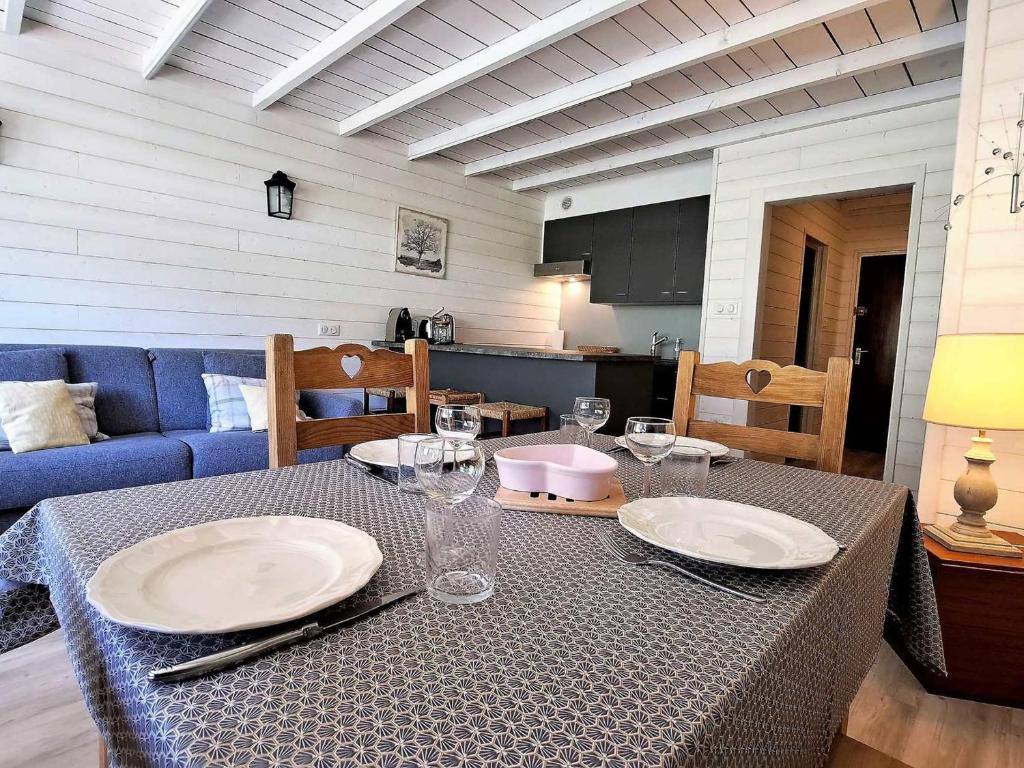 une table avec des assiettes et des verres au-dessus dans l'établissement **Duplex Rénové en Frond de Neige avec Terrasse et Equipements Modernes** - FR-1-165A-179, à Uvernet
