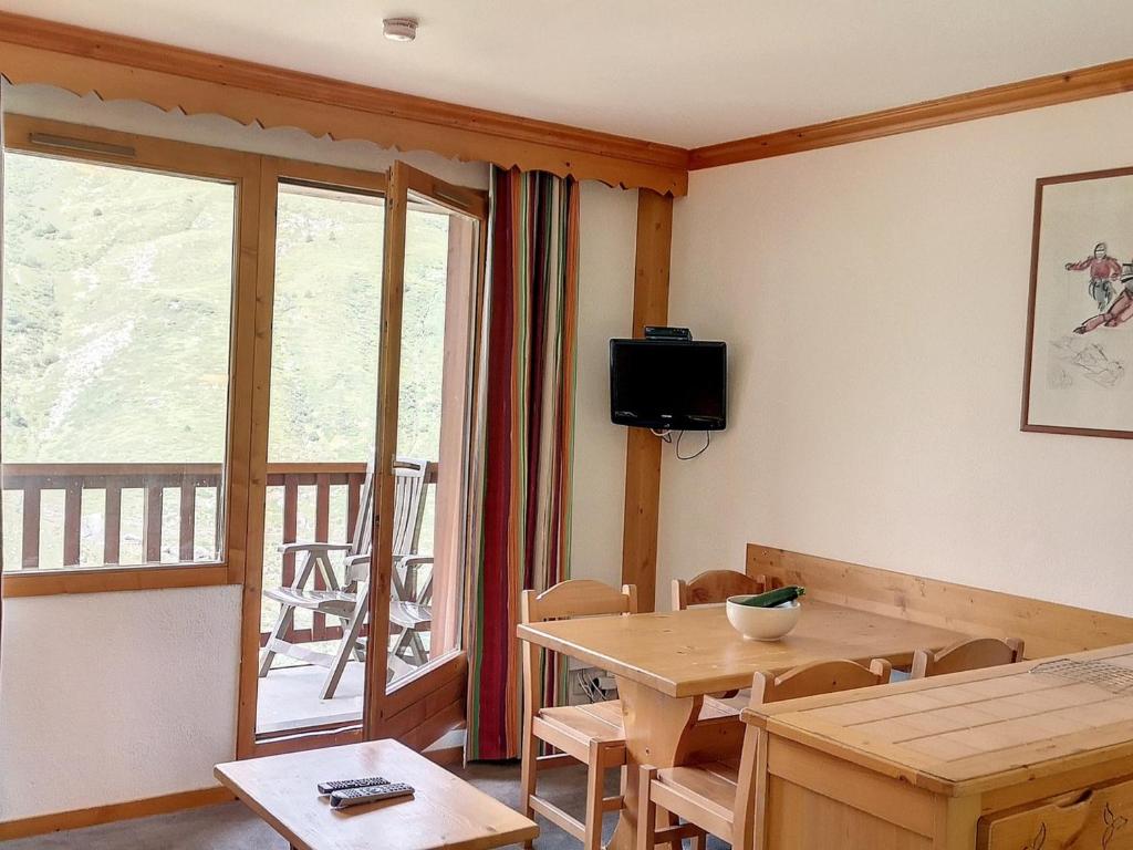 a dining room with a table and a window at Appartement 2 pièces cosy aux Menuires, balcon sud-ouest, pied des pistes, proche commodités - FR-1-178-377 in Les Bruyères
