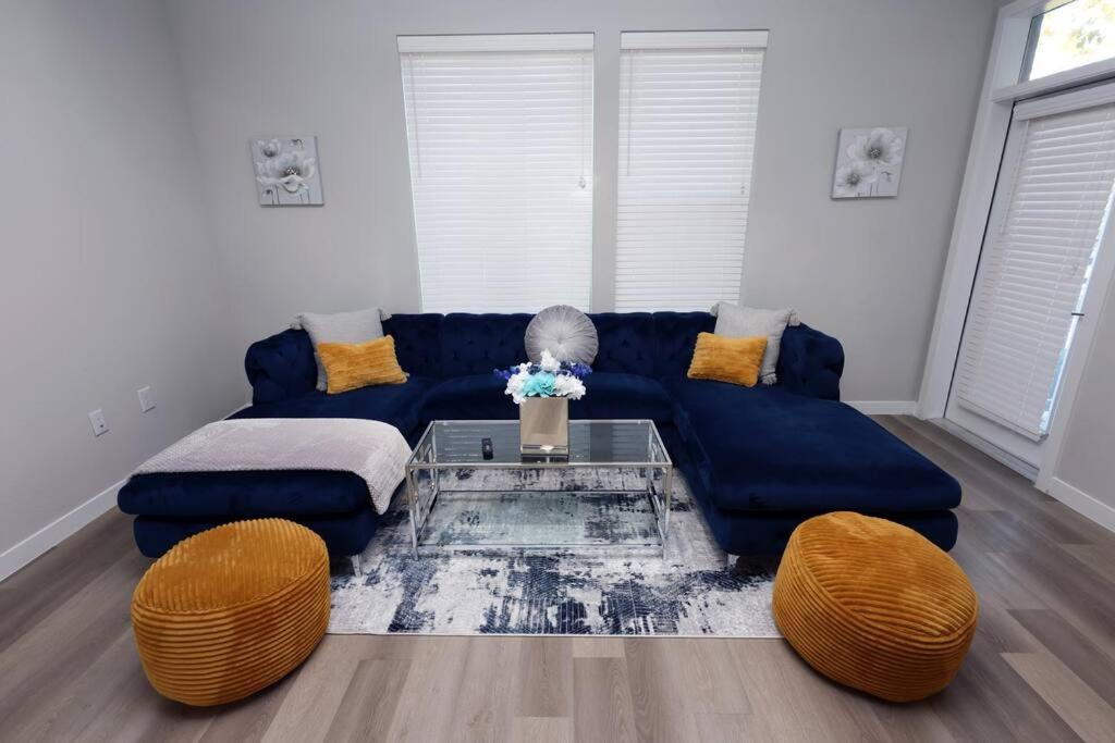 ein Wohnzimmer mit einem blauen Sofa und einem Tisch in der Unterkunft Comfortable Getaway Downtown Htx in Houston