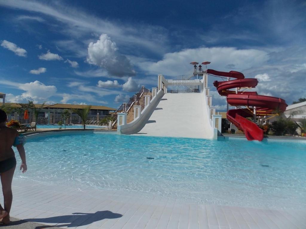 a water slide in the middle of a swimming pool at Via Caldas L'acqua I in Caldas Novas