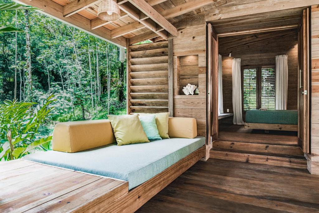 Bocas Garden Lodges في بوكاس تاون: كنب جالس على شرفة منزل خشبي