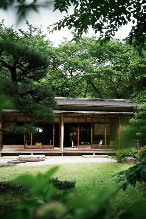 a house with glass doors and a yard at Oukai Villa Izumi in Izumi