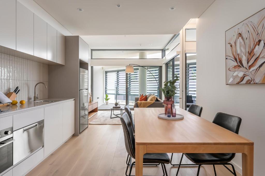 a kitchen and dining room with a table and chairs at Urban Rest Double Bay Apartments in Sydney