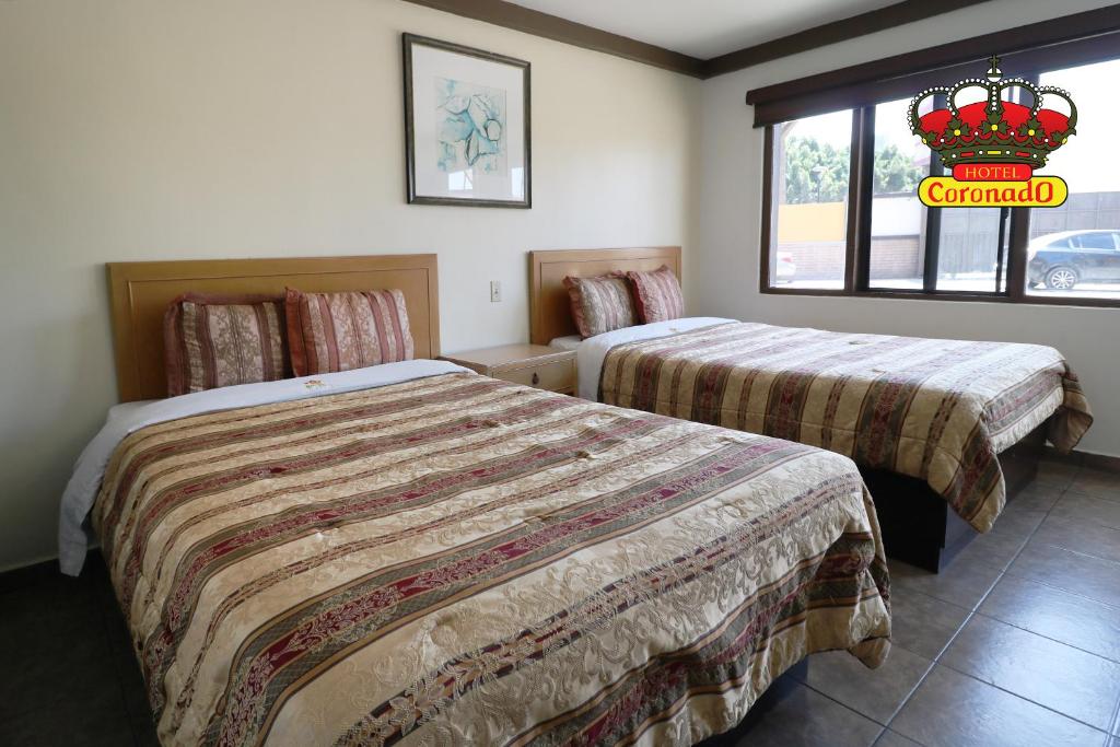 a hotel room with two beds and a window at Hotel Coronado in Ensenada