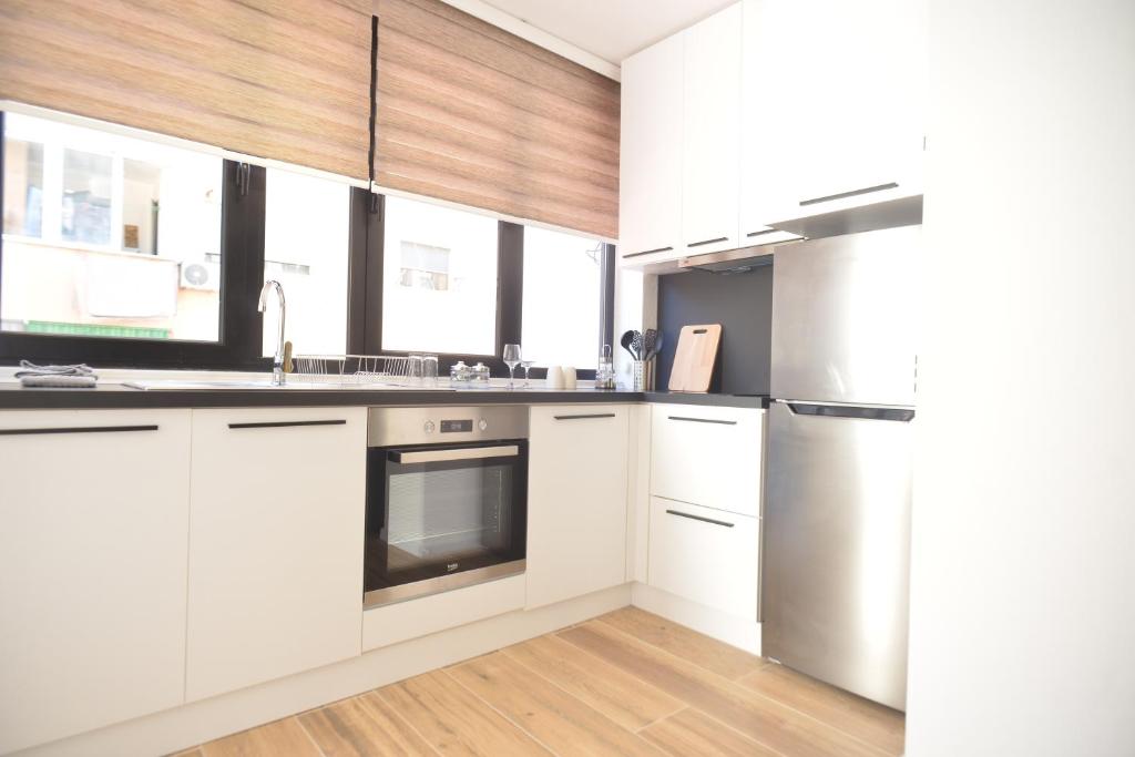 a kitchen with white cabinets and a stainless steel refrigerator at Tirana Central Apartments in Tirana