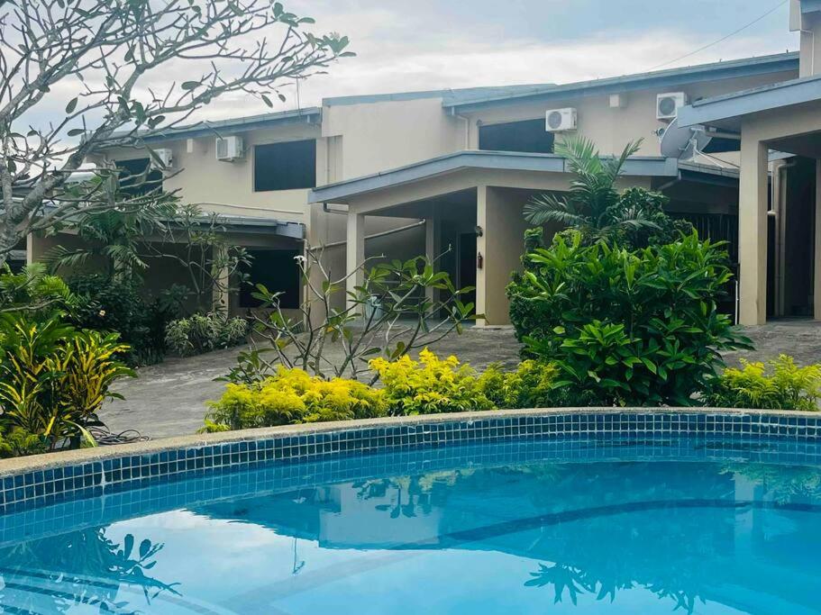 a swimming pool in front of a house at Cozy, Comfortable, Family Home. in Nadi