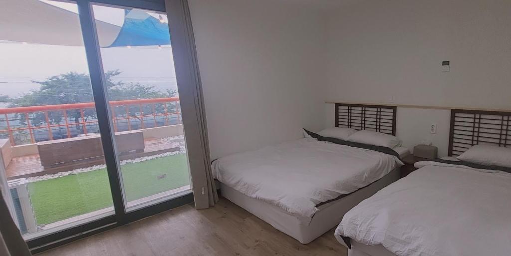 Postel nebo postele na pokoji v ubytování Jeju Soroan Pension