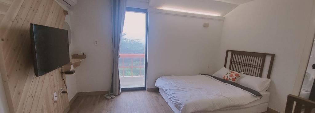 Postel nebo postele na pokoji v ubytování Jeju Soroan Pension