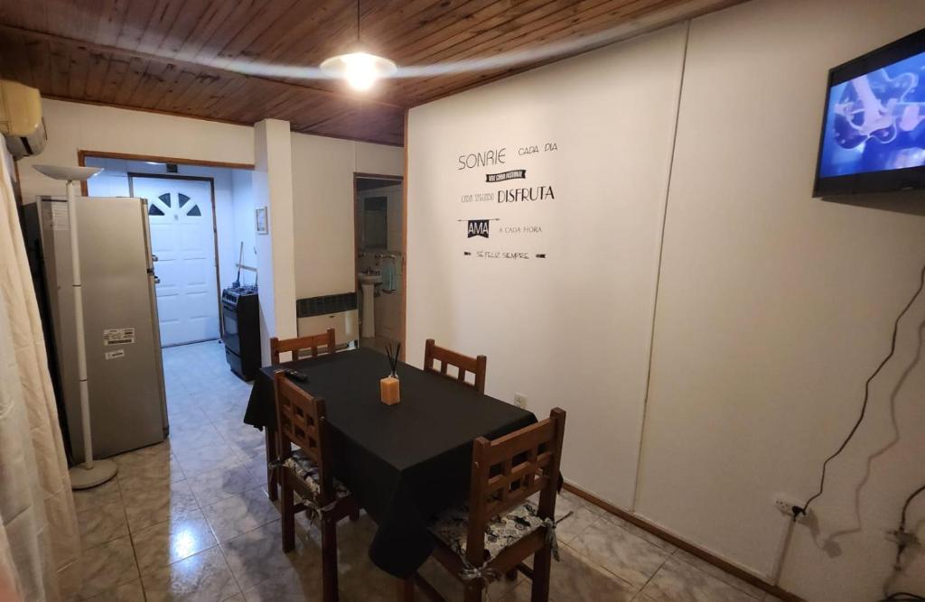 een eetkamer met een tafel en een tv aan de muur bij Departamento Tilcara in Neuquén