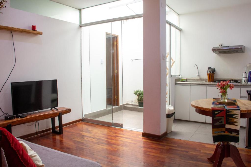 a living room with a tv and a glass door at Apartamento Altoandino in Ayacucho