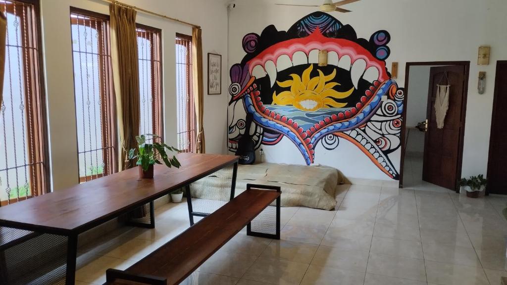 a living room with a large mural of a mouth at Gorga hostel in Timuran