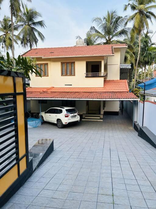 a car parked in a parking lot in front of a house at Saaketh Holiday Home(2) in Kozhikode