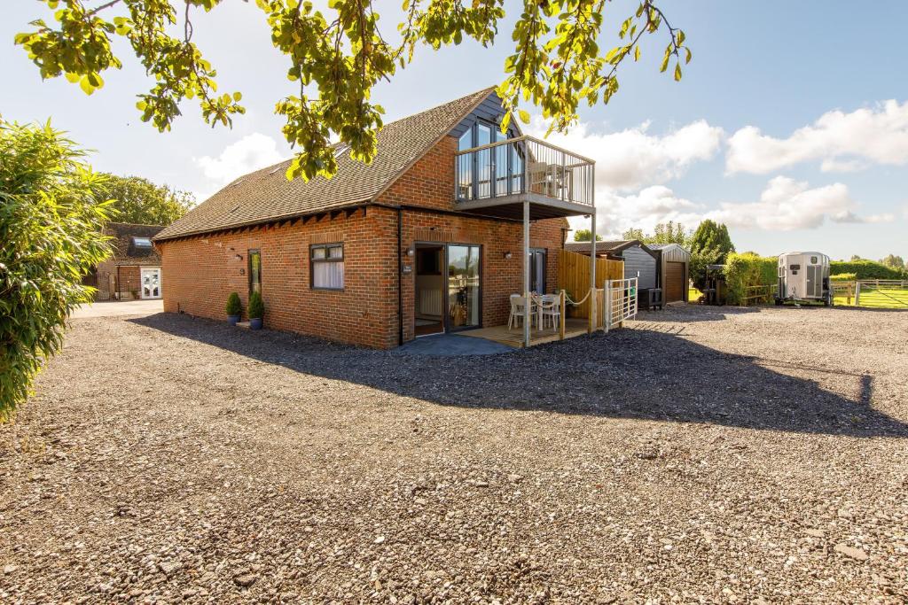 a house on a gravel driveway with a building at The Stables in Chichester