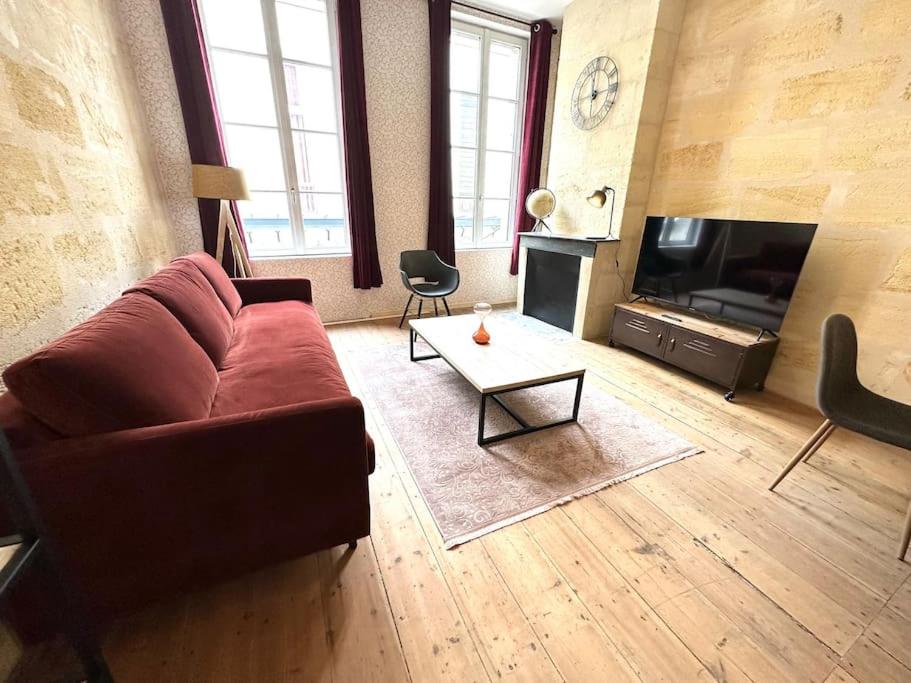 a living room with a couch and a tv at 2 - Hypercentre - FREE Parking - clim - wifi - netflix in Libourne