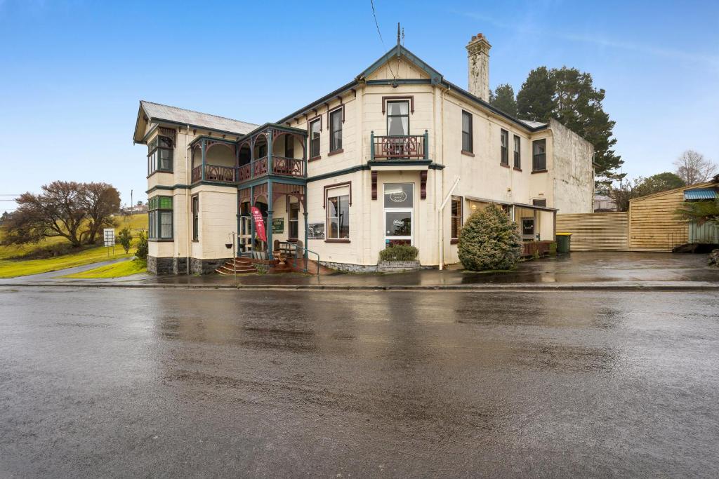 an old house on a rainy street with at Bischoff Hotel in Waratah