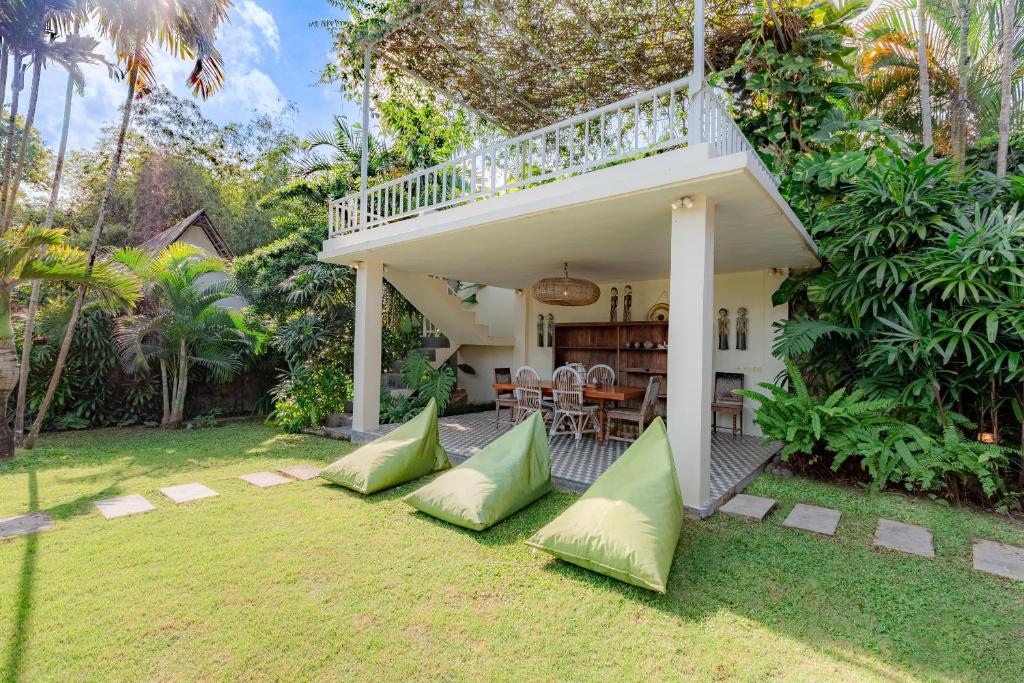 Casa con porche con almohadas verdes en el patio en Villa Bumi en Kerobokan