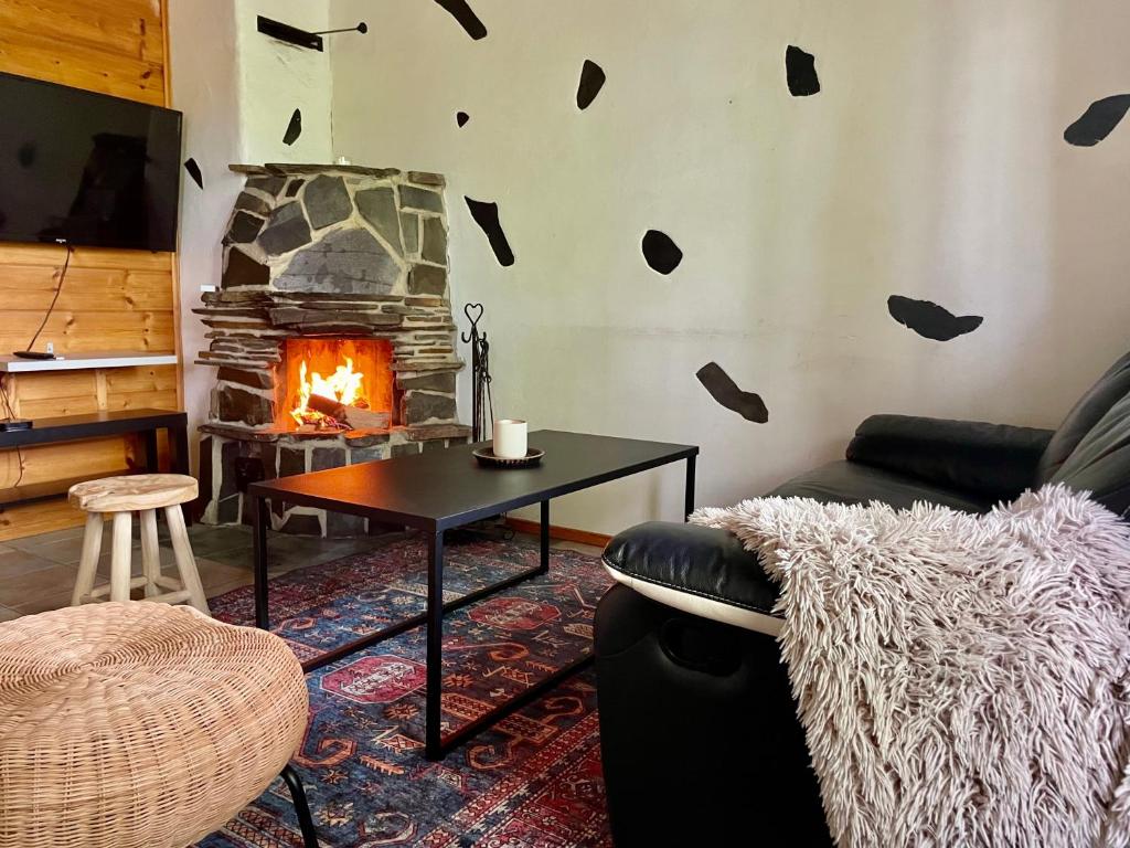 a living room with a couch and a fireplace at Kodikas loma-asunto Tahkon ytimestä in Tahkovuori