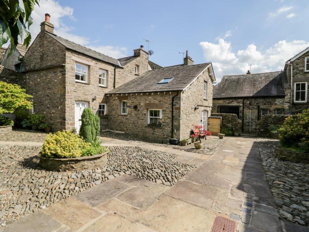 an old stone house with a stone driveway at Ramblers Rest in Sedbergh