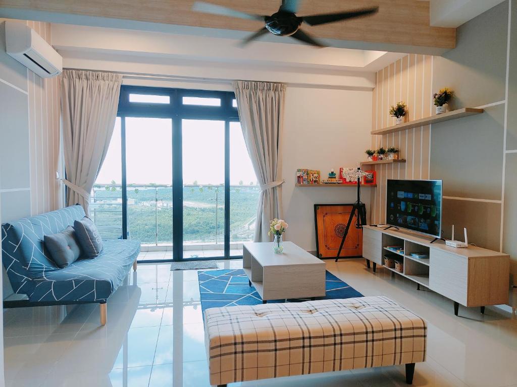 a living room with a blue couch and a tv at Zuncy A37- Medini Legoland Puteri Harbour Iskandar Puteri in Nusajaya