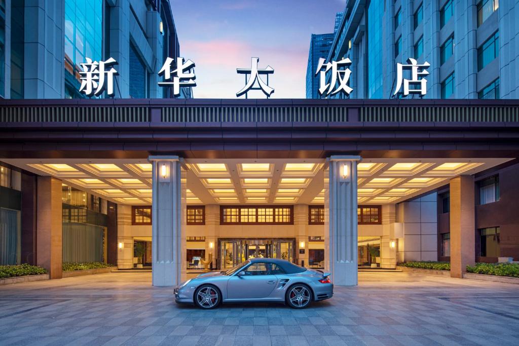 une voiture garée devant un bâtiment dans l'établissement voco Wuhan Xinhua, an IHG Hotel, à Wuhan