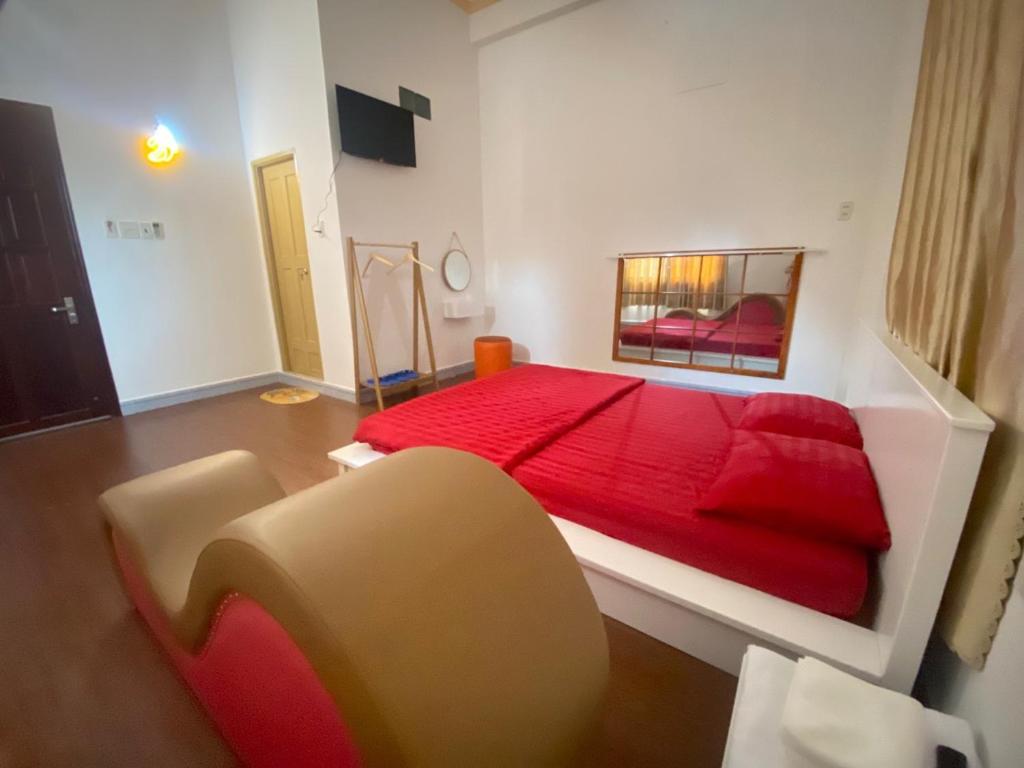 a bedroom with a red bed and a chair at HomeStay 888 in Can Tho