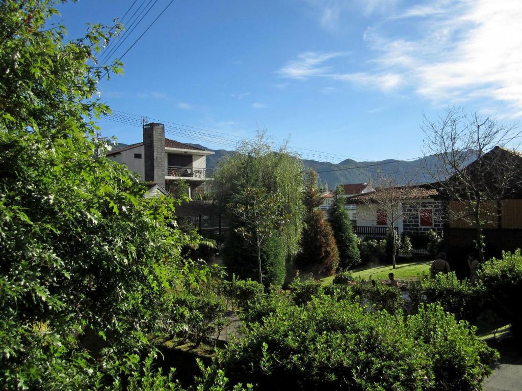 Casa Das Furnas في فورناس: اطلاله على ساحه بها بيوت واشجار