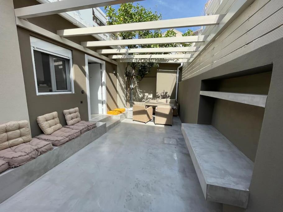 un patio al aire libre con sofá y ventana en Maison centre Athènes en Athens