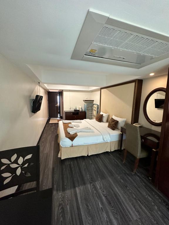 Habitación de hotel con cama, mesa y escritorio. en Maleez Lodge, en Pattaya central
