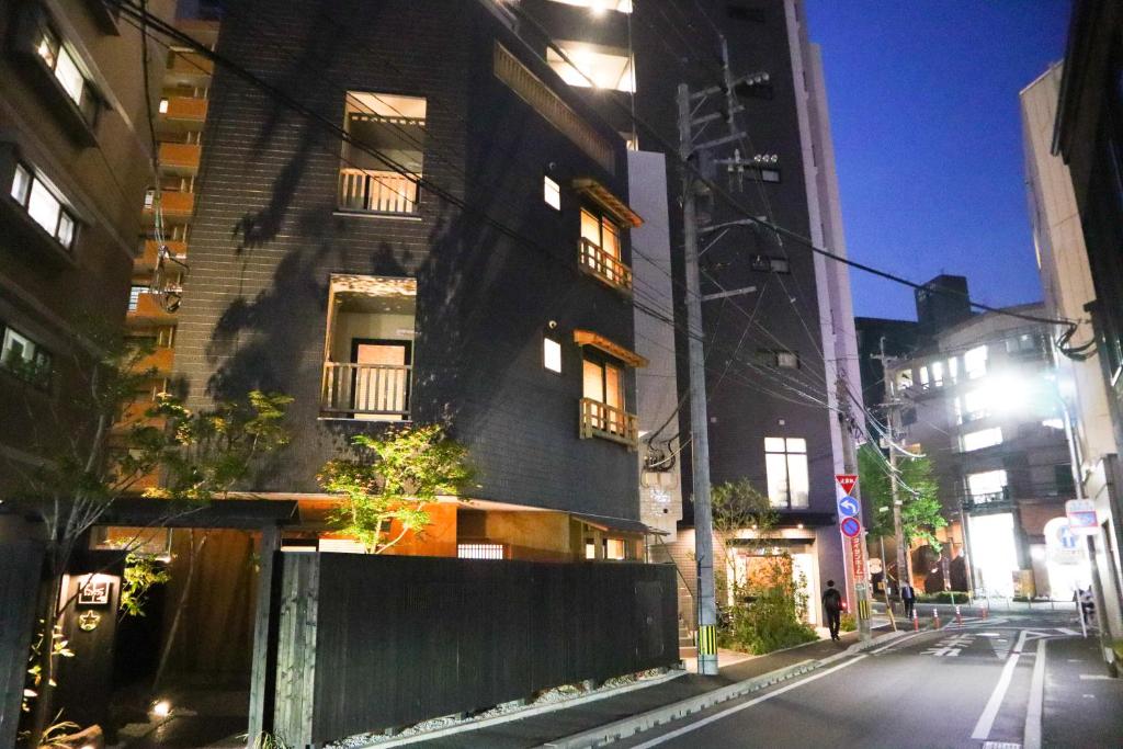 un edificio negro en una calle de la ciudad por la noche en NK Hotels, en Fukuoka