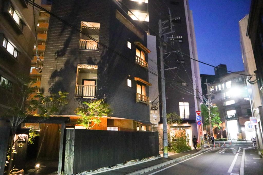 a black building on a city street at night at NK Hotels in Fukuoka
